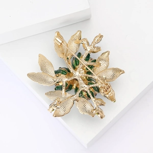 Detailed back view of the golden metal rose brooch showing leaf texture and pin clasp
