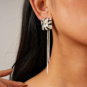 Detail of luxury geometric square tassel earrings with sparkling crystals on model