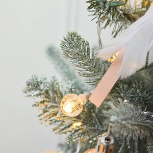 Elegant gold Christmas tree decoration with glowing bubble crystal ball light and white feathers