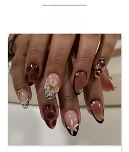 Detail of almond-shaped press-on nails with 3D floral accents and zebra print patterns