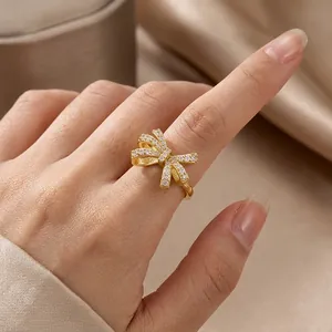 Luxurious gold bow knot ring with inlaid zircons and adjustable open brass band
