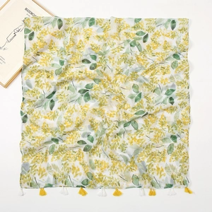 Detail of floral printed scarf with yellow flowers, green leaves and small fringe trim