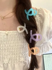Close-up of pastel butterfly claw clips styled on a braided hairstyle for women