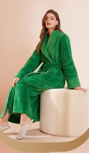 Close-up of emerald green thick plush bathrobe with white piping and textured fleece