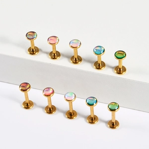 Detailed macro view of gold plated labret studs with colorful opal style gems in various colors