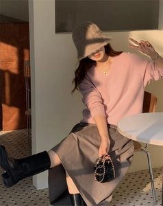 Close-up of a warm faux rabbit fur bucket hat paired with a pink knit sweater for winter