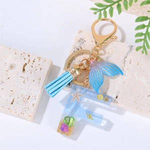 Detail of Letter F resin keychain with starfish, blue mermaid tail, and tassel charms