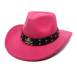 Détail du chapeau de cowboy rose avec bande cloutée et insigne tête de mort en argent