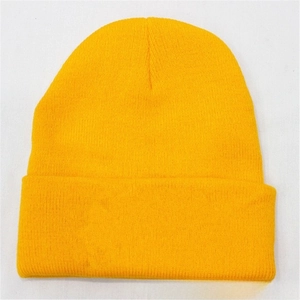 Detailed knit texture of a bright yellow acrylic beanie with ribbed fold-over cuff