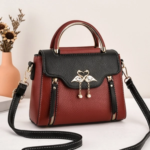 Chic color-block handbag in red and black lychee leather with golden handles