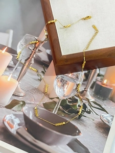 Elegant 18K gold plated stainless steel square bead necklace in a warm lifestyle setting