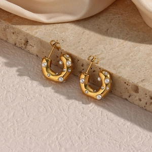Detalle de pendientes de aro en C bañados en oro de 18K con perlas y circonitas blancas