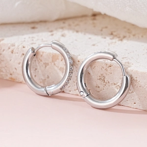 Close-up of polished silver hoop earrings with shimmering cubic zirconia micro-inlay