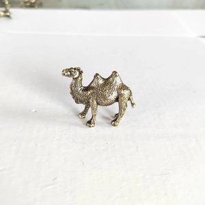 Miniature brass Bactrian camel figurine with detailed fur texture for desert micro landscape