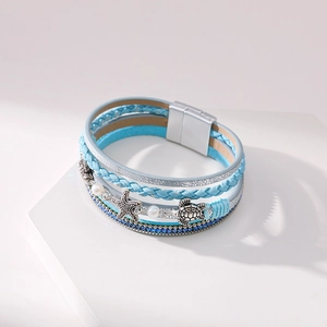 Close-up of multilayer leather bracelet featuring sea star and turtle charms with magnetic clasp