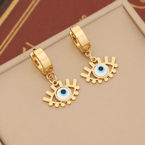 Macro detail of gold-plated evil eye hoop earrings with blue enamel on a jewelry box