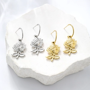 Minimalist rose flower drop earrings in gold and silver finish on white stone