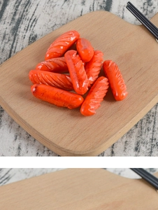 Vue macro de mini saucisses réalistes en PVC sur une planche avec textures grillées