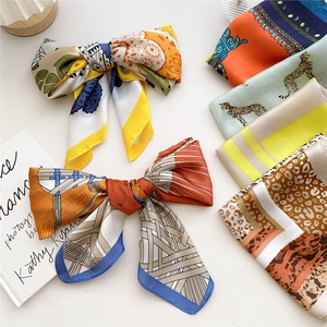 Polished silk scarf set with animal prints and geometric patterns on a beige background