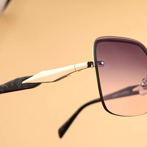 Detailed close-up of gradient lenses and gold metal temples with marble pattern tips
