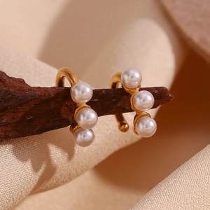 Detail view of 18K gold plated ear cuff with three white pearls on satin background