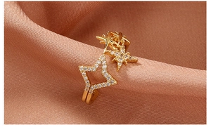 Macro detail of gold adjustable ring featuring pave zircon stars on satin fabric