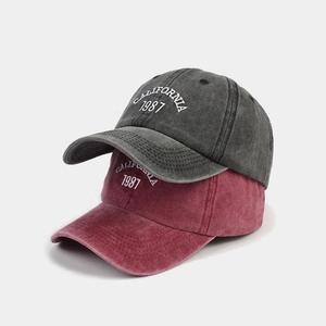 Detailed close-up of washed cotton baseball caps featuring California 1987 embroidery