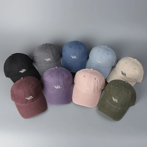 Detail showing various colors of washed cotton baseball caps with embroidered logo