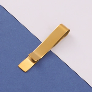 Detailed close-up of a minimalist golden stainless steel tie clip with a mirror finish