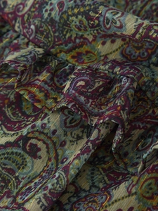 Macro shot of paisley chiffon fabric with metallic gold thread and ruffle detailing