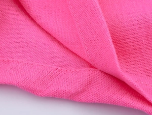 Vue détaillée de la texture du lin rose vif et des finitions de couture de haute qualité
