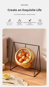 Modern iron fruit basket detail featuring a golden hanging bowl on a black stable frame