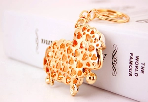 Detail of golden sheep keychain with heart hollow patterns, lobster clasp and a small bell