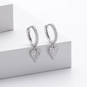 Macro detail of S925 sterling silver heart earrings with sparkling zircon inlay