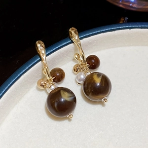 Detailed close-up of marble pattern acrylic drop earrings with gold hooks and pearls