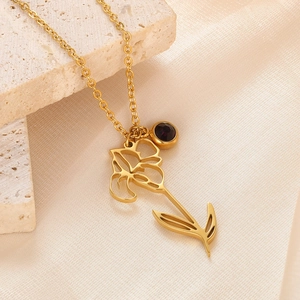Macro detail of 18k gold plated stainless steel floral pendant with purple birthstone