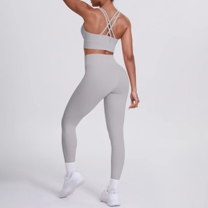 Dettaglio del set yoga grigio chiaro con spalline sottili incrociate e leggings a vita alta