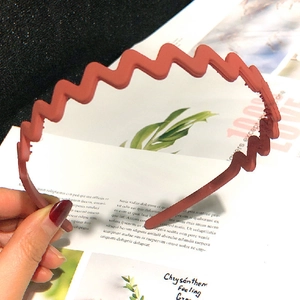Close-up of brick red wavy headband with matte texture for secure daily hair styling