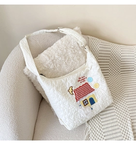 Detailed embroidery of a plush puppy and house on white quilted fabric crossbody bag