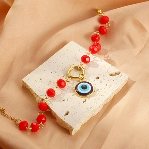 Bohemian red crystal evil eye bracelet in gold titanium steel on silk background