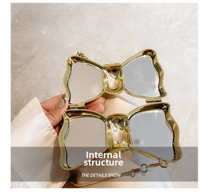 Internal structure of golden bow clutch bag with mirrored interior and delicate chain