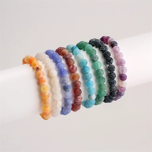 Detail showing eight colors of matte crackle agate beads bracelets on a white display stand