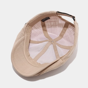 Detail view of khaki cotton newsboy cap featuring 100% cotton mesh lining and adjustable strap