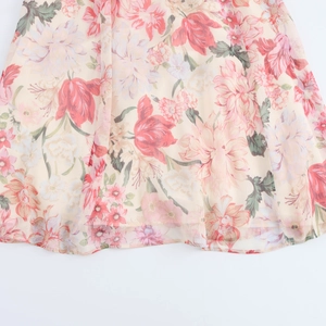 Close-up of floral print chiffon dress hem with detailed pink and red flower patterns