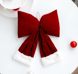 Detail of red velvet Christmas bow featuring plush white faux fur trim on white background