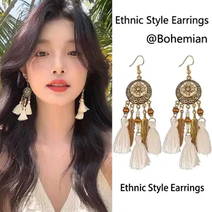 Detail view of Bohemian tassel earrings with metallic feathers and woven beads