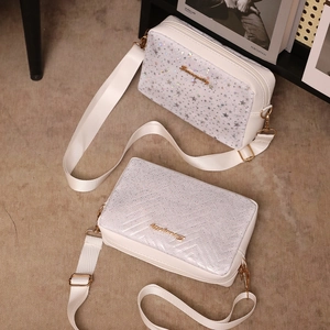 Chic white and silver crossbody camera bag with star pattern and gold logo detail