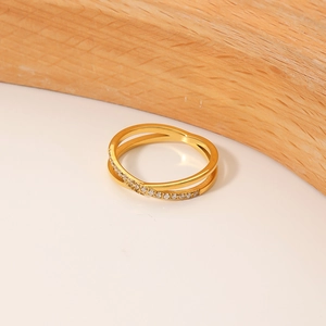 Elegant gold double-layered crisscross ring with micro-pave crystals on white background