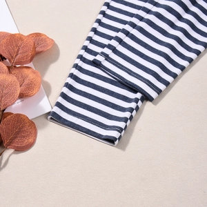 Detailed macro view of the blue and white striped fabric texture and knitted hem finish