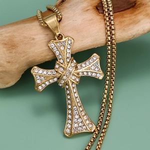 Vintage punk gold cross necklace with shimmering zircon crystals on wooden branch